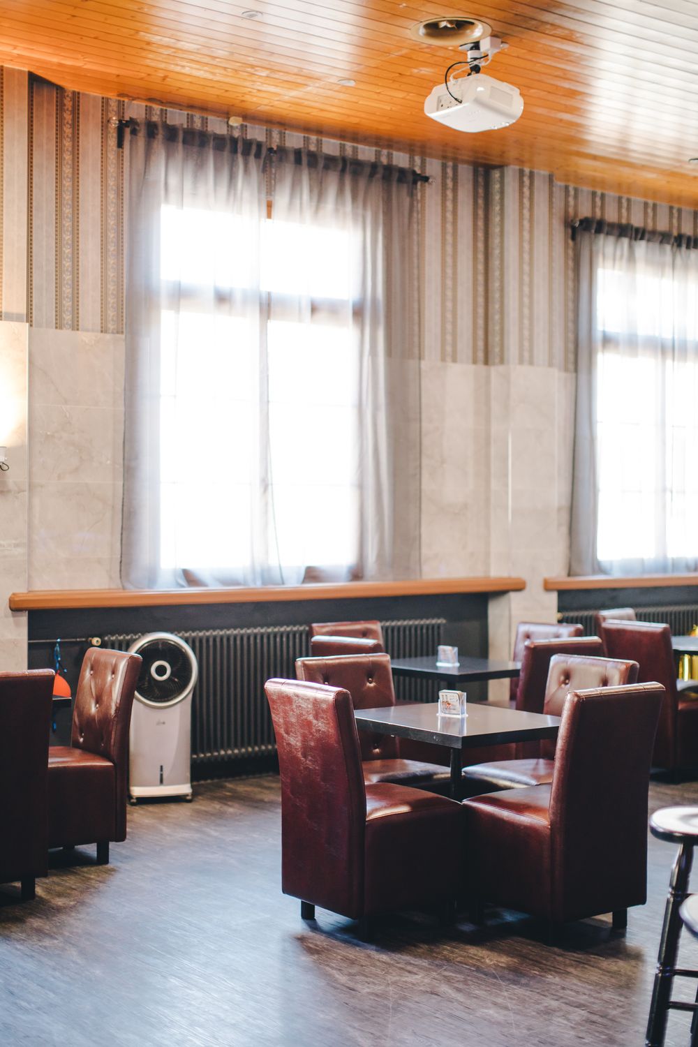 Sessel um niedrige Tische an den Fenstern der Bar