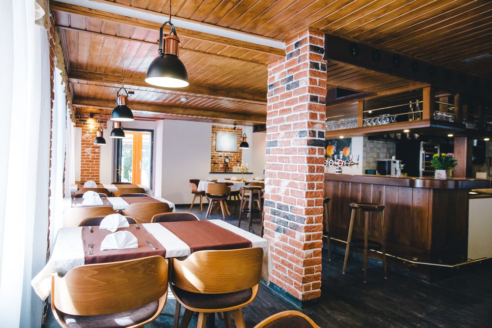 Gedeckte Tische zwischen den Ziegelsäulen im Restaurant