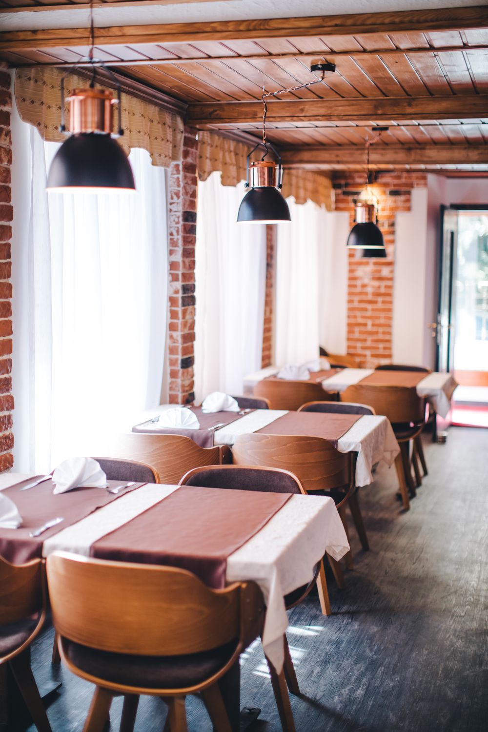 Fenstertische im Restaurant, in Weiss und Braun eingedeckt
